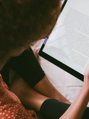 Person reading the ebook Xarevās Azyk, an enchanting artificial language inspired by Croatian and Slavic influences.